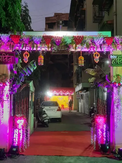 A beautifully lit entrance gate for a Haldi night. The purple uplighting adds a modern touch to the traditional floral decor.
