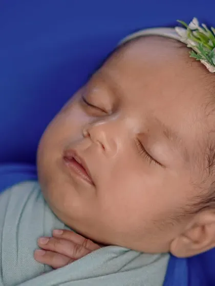 Baby's first chapter. This close-up on a swaddled baby's face is all about capturing the pure, untouched innocence of their first few weeks.