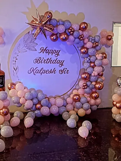 A fun adult birthday theme with a whiskey bottle foil balloon and a personalized backdrop.