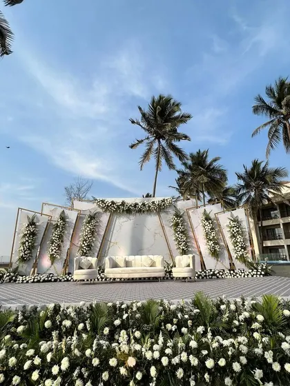 A wide shot of the stunning white-themed beach wedding stage, showing the full scale of the setup.