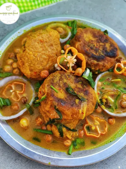 Pakora Thongba, which are fritters simmered in a flavourful chickpea curry, garnished with fresh chillies.