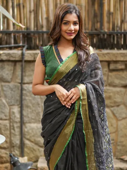 A black linen saree with delicate embroidery, paired with a green ruffled blouse. This shows how my lightweight sarees can be styled for a chic, modern look.
