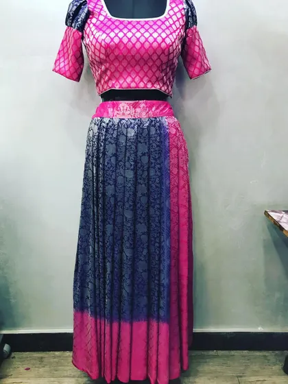 This two-tone lehenga was upcycled from a brocade saree. The pink blouse and blue pleated skirt show how different parts of a saree can be combined.