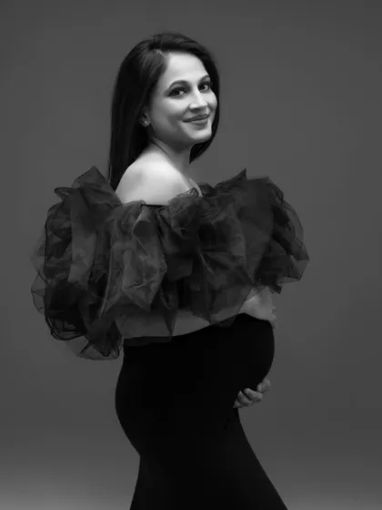 A beautiful black and white close-up, highlighting her smile and the texture of the ruffled gown.