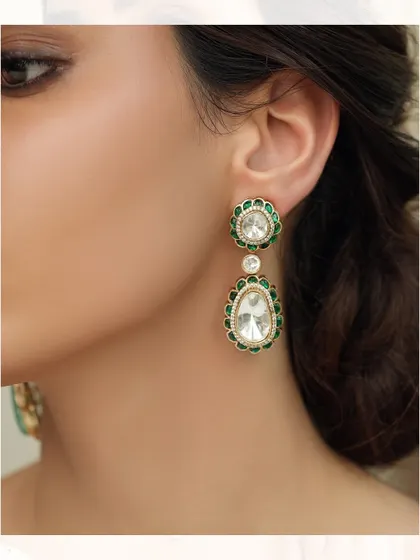 Elegant drop earrings with a floral stud and a larger teardrop-shaped polki, both framed with green enamel.