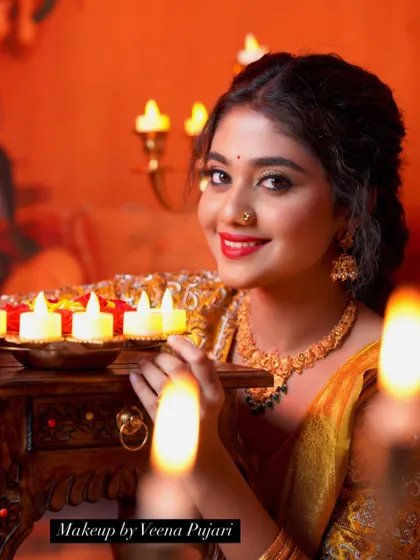 A beautiful shot from a Deepavali-themed photoshoot. The warm lighting from the diyas enhances the glow of the makeup.