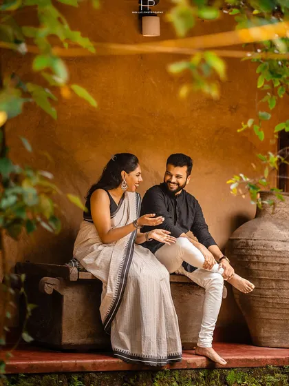 A candid shot of a couple having a conversation on a stone bench. Their natural interaction and traditional attire create a scene that is both beautiful and authentic.