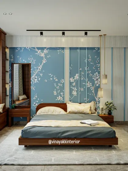 This bedroom design uses a beautiful blue floral wallpaper as a feature wall, creating a sense of calm and serenity. The low wooden bed frame and integrated window seat add to the room's modern, clean aesthetic.