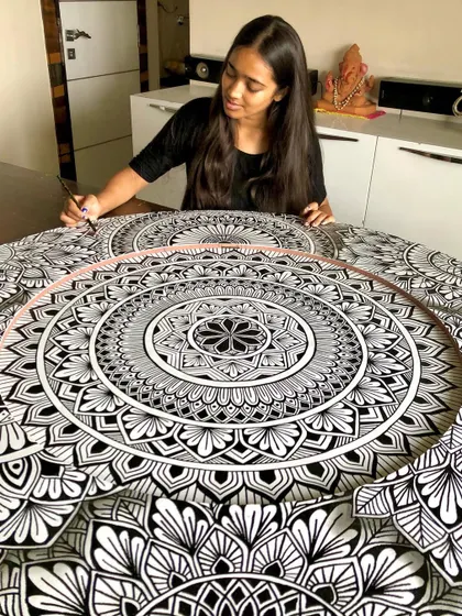 A soothing process. A shot of me working on the layered mandala, completely absorbed in the repetitive, meditative patterns.