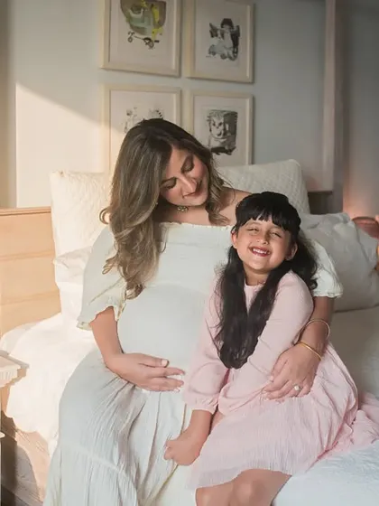 The joy of becoming a big sister! This heartwarming photo captures a tender moment between mother and daughter, both excited about the new arrival.