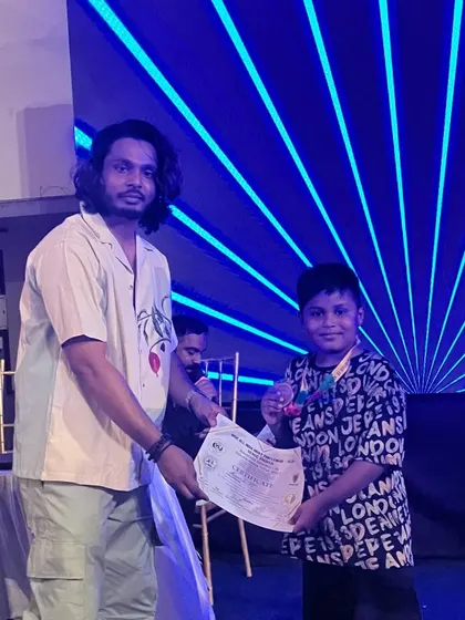 Our young fighter proudly accepts his certificate and medal. These experiences are invaluable for building character.