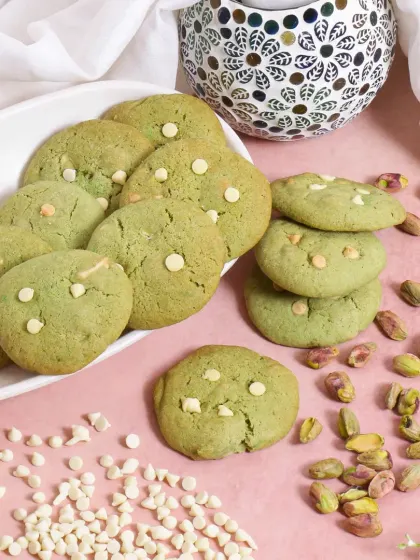 A playful and abundant composition for pistachio white chocolate cookies. The scattered pistachios and chocolate chips create a sense of generosity and deliciousness, making the cookies look irresistible.