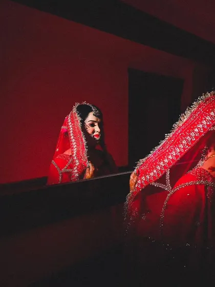 A creative bridal portrait using a mirror to capture the bride's reflection. This adds a layer of depth and introspection to the image.