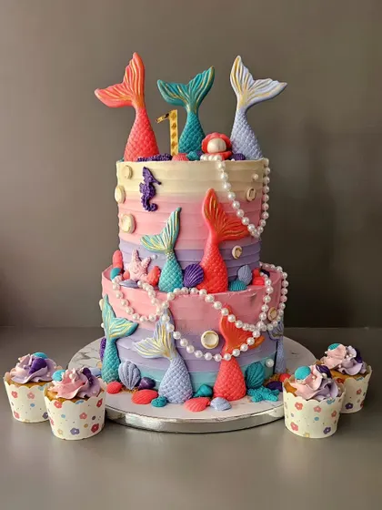 The underwater treasure box! A 3.5kg butterscotch cake for a first birthday, decorated with mermaid tails, pearls, and seashells. It's a magical centerpiece for a mermaid party.