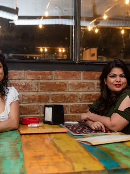 Two friends having a chat at one of our colorful tables. It's a great place to catch up.