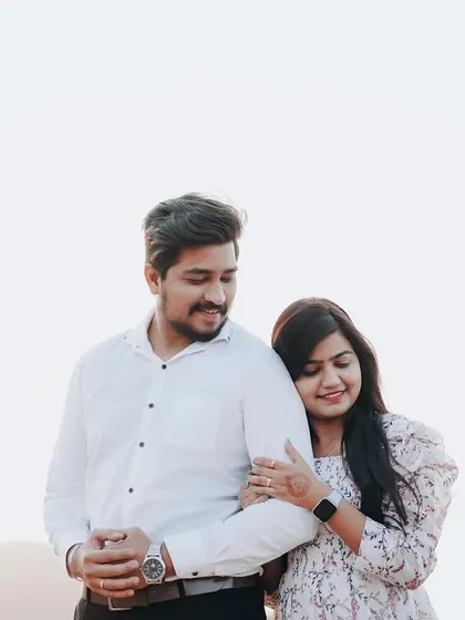 A comfortable and sweet pose, with her resting on his shoulder. It shows the trust and ease they share.