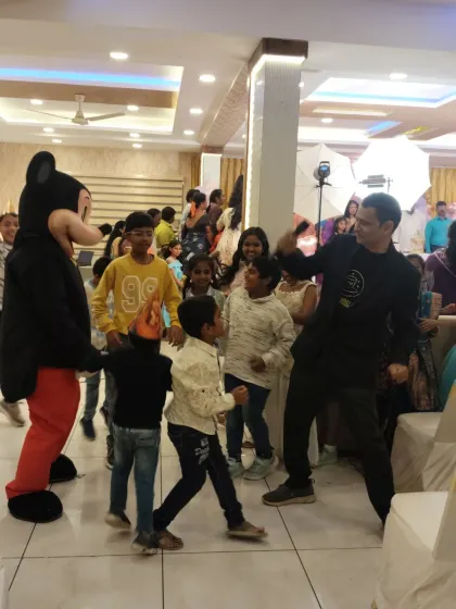 There's nothing like the energy of a kids' party. Here I am, right in the middle of the dance floor with the children and a Mickey Mouse mascot, making sure everyone is having a great time.