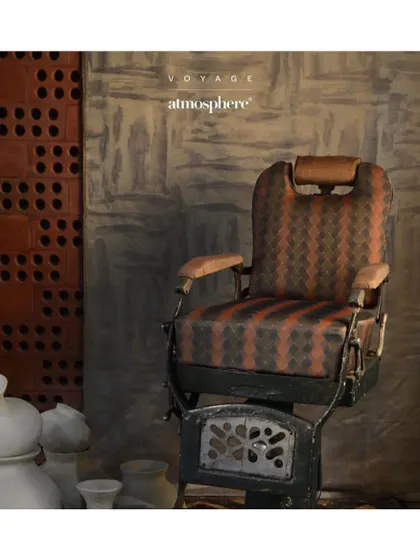 The 'Stagecoach' fabric from the 'Voyage' collection has a timeless, classic feel. Its geometric pattern and earthy tones are ideal for upholstering a vintage-style chair, adding a touch of heritage to a formal drawing room.