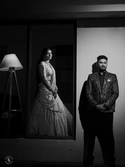 A dramatic black and white portrait of the couple, using strong light and shadow to create a cinematic and timeless feel for their Sangeet look.