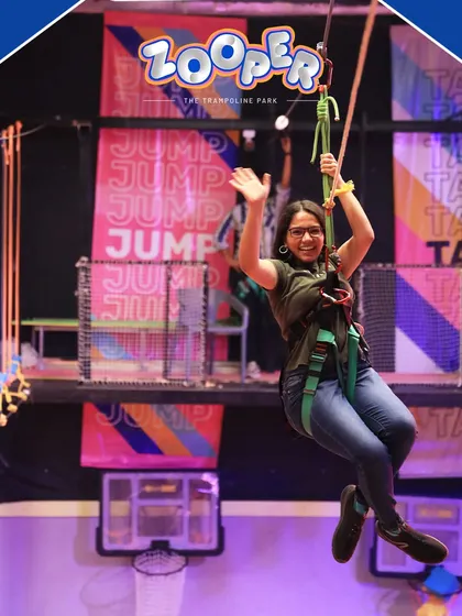 A team member enjoys the thrill of the zipline, flying over the park. It's an exhilarating experience that makes any corporate outing memorable.