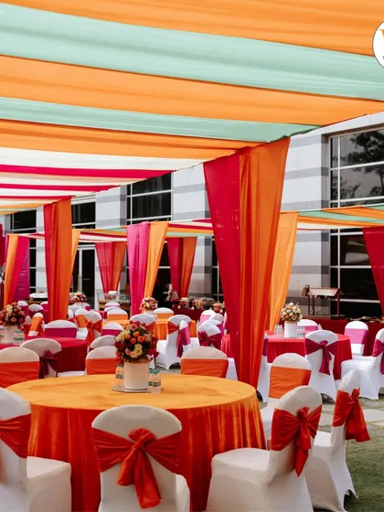 I love working with color to create a festive atmosphere. For this outdoor Mehendi, we used vibrant orange, pink, and mint drapes to create a cheerful canopy, setting the perfect mood for a daytime celebration.