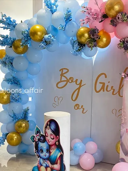 A detailed shot of the gender reveal setup, focusing on the 'Boy or Girl' text and the intricate balloon and floral arrangements.