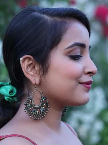 A side profile showcasing a simple yet elegant makeup look. The focus is on a clean winged liner, well-defined brows, and a touch of berry on the lips.