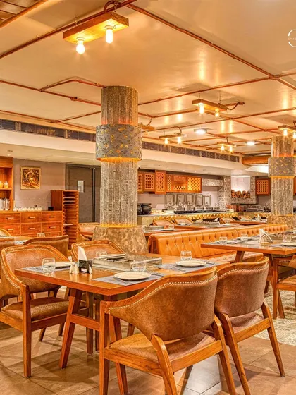Another view of the dining space, showing the repetition of design elements like the textured pillars and leather-upholstered chairs. This consistency creates a strong and cohesive brand environment.