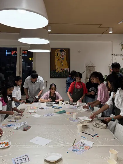 A wide shot of our studio during a kids' birthday party. The long tables provide plenty of space for everyone to get creative with their mosaic art projects.