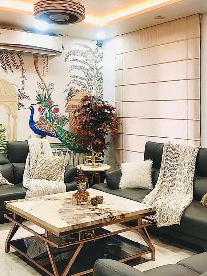 For this living room, we brought nature indoors. A beautiful, hand-painted style wallpaper featuring peacocks and foliage serves as the backdrop, complemented by neutral leather sofas and a majestic horse painting.