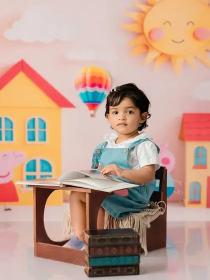 A playful Peppa Pig theme, where this little girl is "reading" a book in a colorful, cartoon-inspired world.