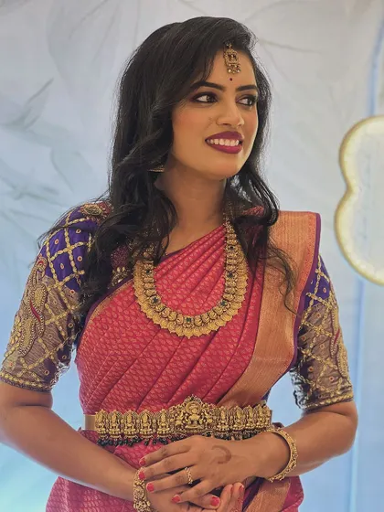 A beautiful guest makeup look for a reception. The client's wavy hair is left open, and the makeup is glamorous with a bold berry lip and smokey eyes.