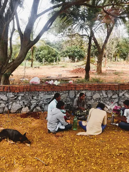 Our team takes a well-deserved break together against a newly built gabion wall. These moments of community are just as important as the work itself.