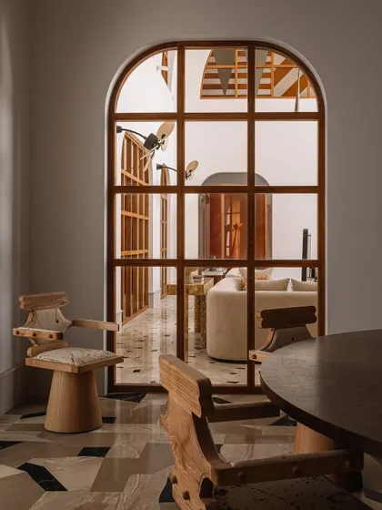 A detail of the 'Kingpin' chairs, which are perfect for long conversations at the dining table. The view looks through an arched window into another living space.