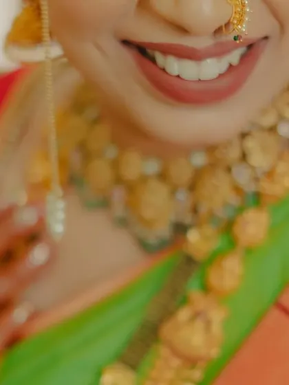 A close-up on the bride's joyful smile, with her beautiful necklace in soft focus, capturing a moment of pure happiness.