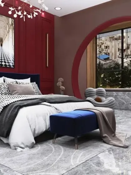 We have a love for arches, and this bedroom shows why. A bold circular window acts as the main feature, complemented by a rich red accent wall and a deep blue bed, creating a unique and lavish space.