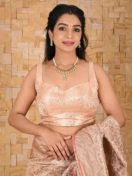 This model pairs a brocade blouse with a delicate white beaded necklace. The simplicity of the jewellery allows the texture and color of her outfit to shine.