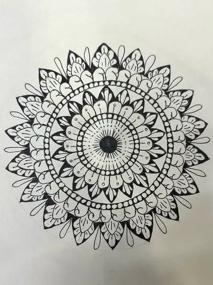 A student's finished black and white mandala from one of my beginner sessions. The clean lines and balanced patterns show a great understanding of the core principles we learned.