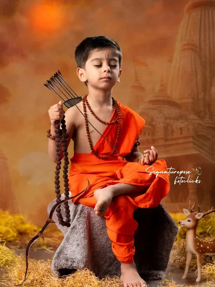 A serene portrait of a young boy as Lord Rama in meditation. The background, depicting a temple at sunset, and props like the bow and arrow are carefully chosen to reflect the divine and peaceful nature of the character.