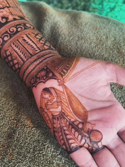 A beautiful bridal figure drawn on the palm. This design element shows the bride in her wedding attire, holding a 'diya', symbolizing the light she brings to her new family.