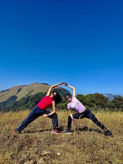Creating a heart shape with a partner in a modified triangle pose. This shows the fun and connection we foster in my group retreats.