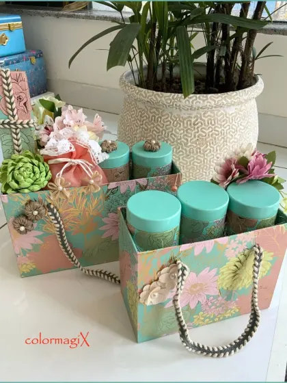 Our floral patterned gift bags filled with matching canisters. This image shows how even our simpler gift bags are designed with elegance, featuring sturdy rope handles and decorative embellishments.