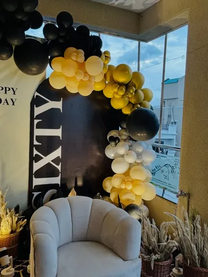 Another angle of the 60th birthday decor, showing the comfortable seating and pampas grass arrangements that add a touch of boho-chic to the modern setup.