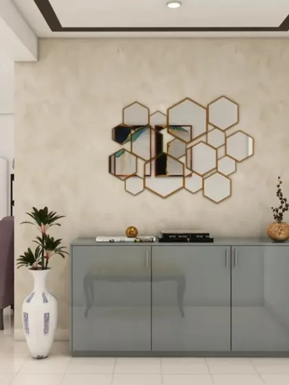 A glossy grey console table is paired with a geometric honeycomb mirror to create a chic and modern foyer. The look is clean, reflective, and perfect for smaller spaces.