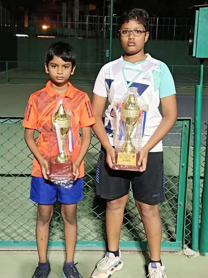 Hitesh and Harshad holding their trophies after winning at a state championship tennis tournament. Building a strong foundation from a young age is key.