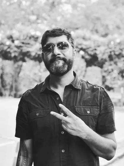 A black and white portrait of a rider, adding a timeless and classic feel. The peace sign and relaxed expression capture the friendly and open spirit of the biker community.