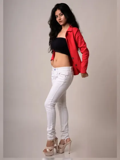 A bold and stylish studio shot. The red jacket provides a pop of color, while the model's confident pose commands attention.