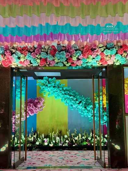 The entrance to the pastel-themed event, with a floral garland framing the doorway.