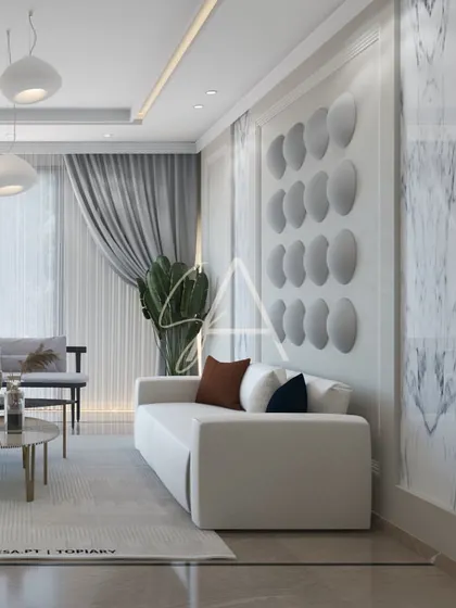 A lounge area where texture plays a key role. The 3D wall panels, marble-patterned accents, and soft fabrics on the sofa come together to create a space that is visually interesting yet soothing.