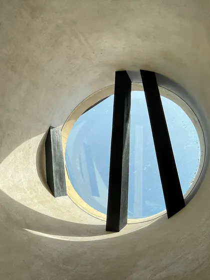 A circular skylight at the House of Galleries in Kutch, framed by the geometry of wooden rafters. The design not only illuminates the space but also brings a touch of the sky indoors, connecting the home to the world outside.